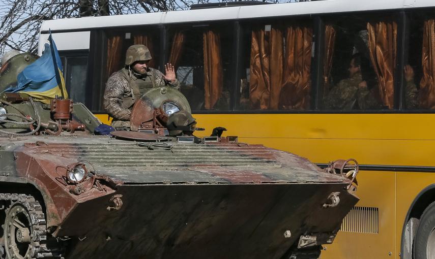 Miembro de las fuerzas armadas ucranianas da la bienvenida a sus compañeros sentados en el autobús, que se preparan para la vuelta a casa, en Artemivsk, este de Ucrania./REUTERS-Gleb Garanich