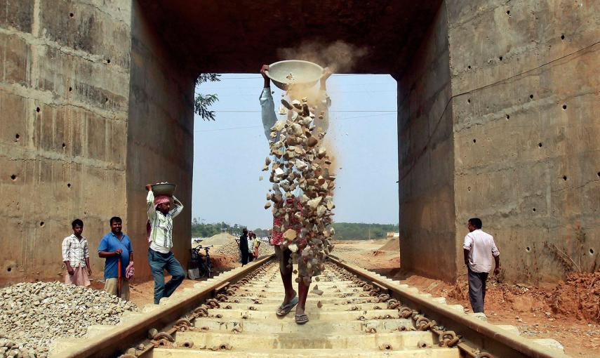 Varios operarios trabajan en la instalación de una nueva vía férrea a las afueras de Agartala, capital del estado indio de Tripura. /JAYANTA DEY (REUTERS)