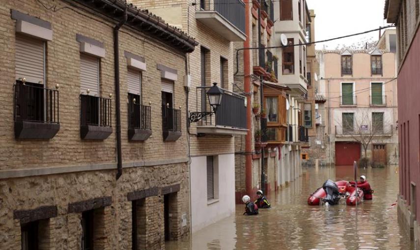 Voluntarios de Cruz Roja recorren las calles anegadas por el agua del casco histórico de Tudela (Navarra) para atender a los vecinos que han quedado incomunicados por la crecida del río Ebro, que se ha desbordado tras las intensas precipitaciones de esto
