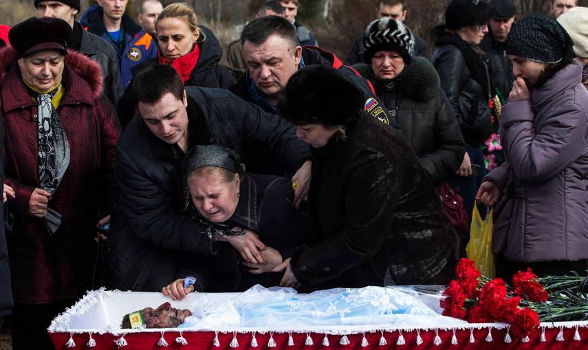 Familiares de un minero, Dmitri Aleksandriv, lloran junto a su ataúd. 33 mineros perdieron la vida tras una explosión en una mina de carbón, en la ciudad ucraniana de Donetsk, cerca del frente de batalla en el este del país. /MARKO DJURICA (REUTERS)