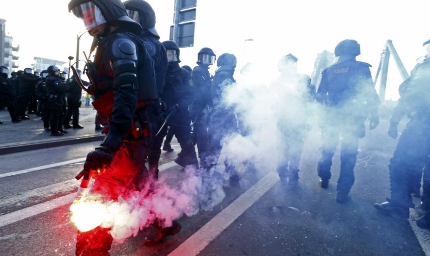 Un polcía sostiene una antorcha en la protesta de 'Blockupy', movimiento anticapitalista, cerca del Banco Central Europeo antes de la apertura oficial de la nueva sede en Frankfurt./ REUTERS-Ralph Orlowski