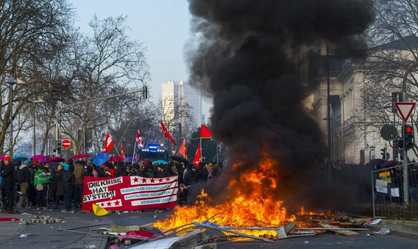 Manifestantes prenden mobiliario urbano durante una protesta ante la nueva sede del Banco Central Europeo (BCE) en Fráncfort (Alemania)./ EFE-Andreas Arnold