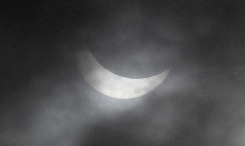 El eclipse parcial de sol a través de las nuves en Dunte. REUTERS/Ints Kalnins