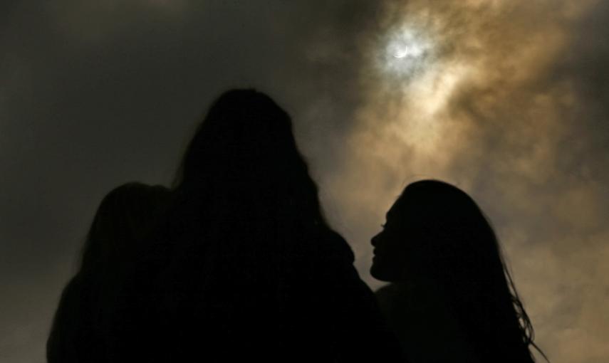 Unas personas observan desde el Zoo de Belfast el eclipse parcial de sol. REUTERS/Cathal McNaughton