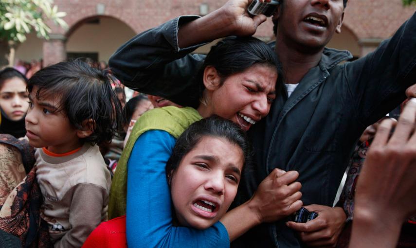 Varias personas lloran la muerte de un familiar, víctima de un atentado suicida contra una iglesia, durante su funeral en Lahore. /MOHSIN RAZA (REUTERS)