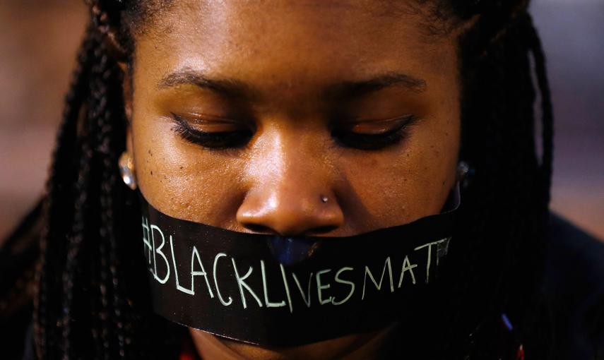 Una manifestante, con cinta adhesiva en la boca durante una manifestación silenciosa, contra la brutalidad policial, tras el tiroteo en Ferguson en el que murió un adolescente negro desarmado por los disparos de un policía blanco. /JIM YOUNG (REUTERS)