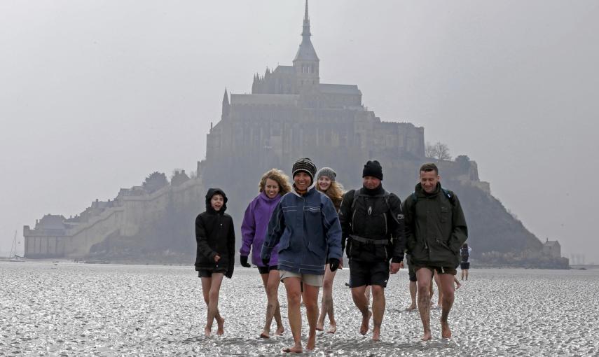 Un grupo de personas camina por las marismas en marea baja hacia el Mont Saint-Michel, en Normandía. REUTERS / Pascal Rossignol