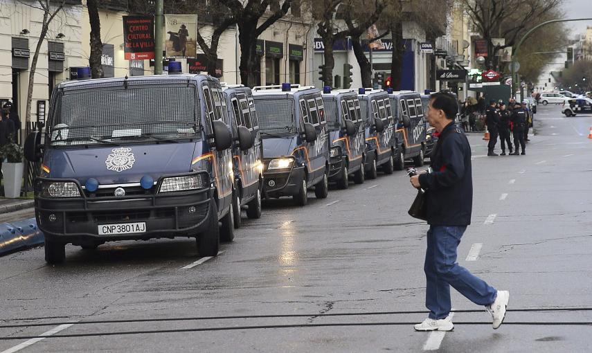 Un hombre pasa junto a las furgonetas policiales desplegadas en la Calle Goya, junto a la Plaza de Colón, punto de llegada de las Marchas por la Dignidad. EFE/Ballesteros