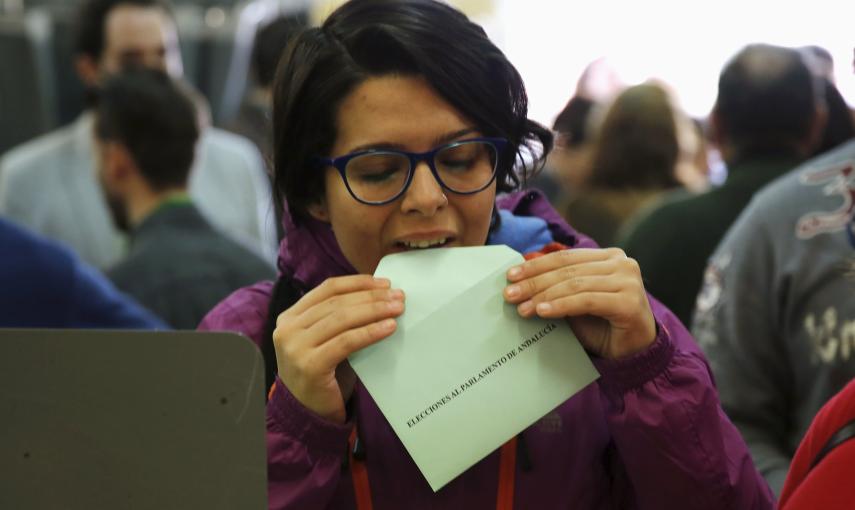Una mujer cierra el sobre con su voto en un colegio electoral de Sevilla, para las elecciones autonómicas de este 22-M. REUTERS/Marcelo del Pozo