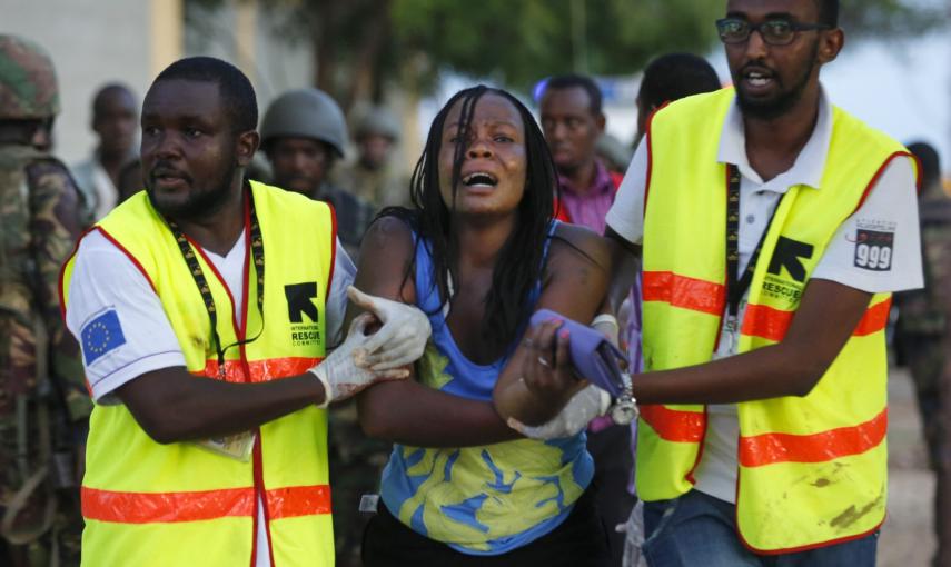 Dos sanitarios ayudan a una mujer que ha escapado de la Universidad de Garissa, en el este de Kenia, donde al menos 147 personas han muerto en un ataque con rehenes reivindicado por el grupo islamista Al Shabab.- Dai Kurokawa (EFE)