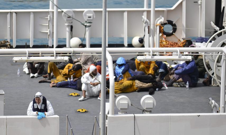 Inmigrantes descansan tras haber sido rescatados a bordo del barco Gregoretti en el puerto de la Valeta en Malta . /Ivan Consiglio (EFE)