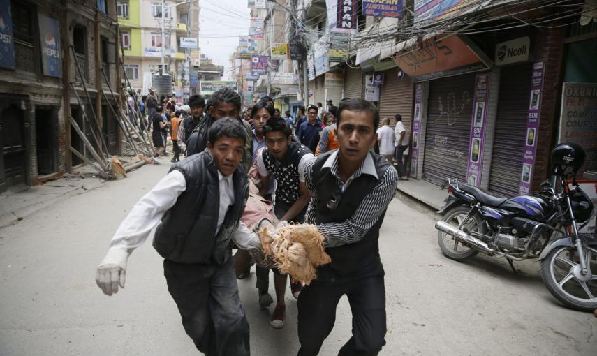 Un grupo de hombres trasladan a una persona herida a través de la calle después de que un terremoto causara graves daños en Katmandú, Nepal.- EFE / EPA / NARENDRA SHRESTHA