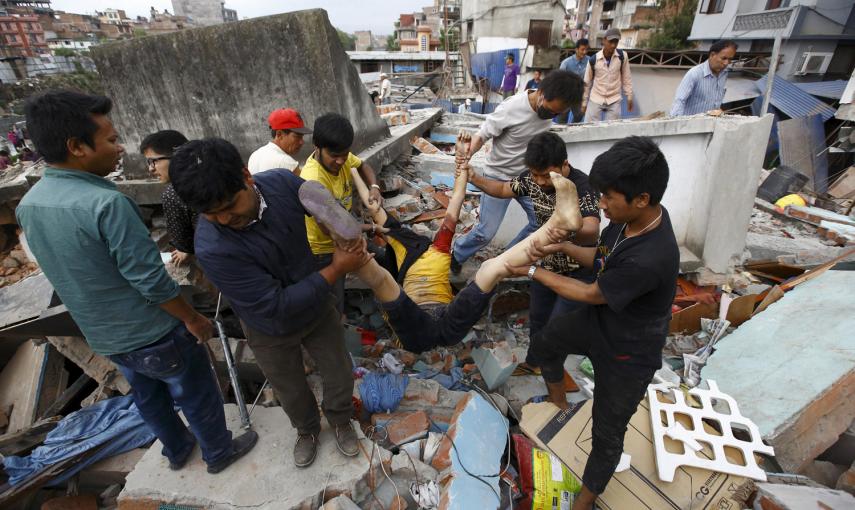 La gente lleva el cuerpo de una víctima de una casa dañada después de un terremoto, en Katmandú, Nepal.- REUTERS / Navesh Chitrakar
