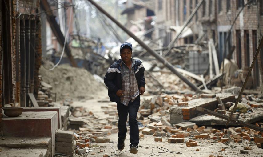 Un hombre corre entre las casas dañadas por el terremoto mientras se producen réplicas en Bhaktapur, Nepal.- REUTERS / Navesh Chitrakar