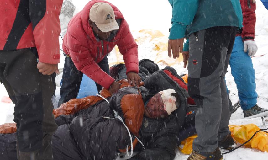 Fotografía tomada el 25 de abril de 2015. Los equipos de rescate atienden a un sherpa herido por la avalancha que arrasó partes del campamento base del Everest.- AFP PHOTO / Roberto SCHMIDT