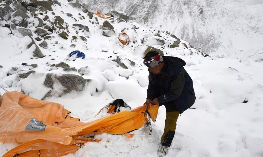 En esta fotografía tomada el sábado, el guía de la expedición Pasang Sherpa busca supervivientes entre tiendas de campaña arrolladas por la avalancha producida en el Everest por el primer terremoto.- AFP PHOTO / Roberto SCHMIDT