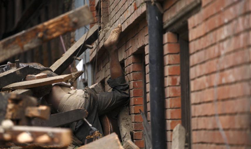 El cuerpo de una víctima del terremoto, entre los escombros de una casa derrumbada en Bhaktapur, Nepal.- REUTERS / Gopen Rai