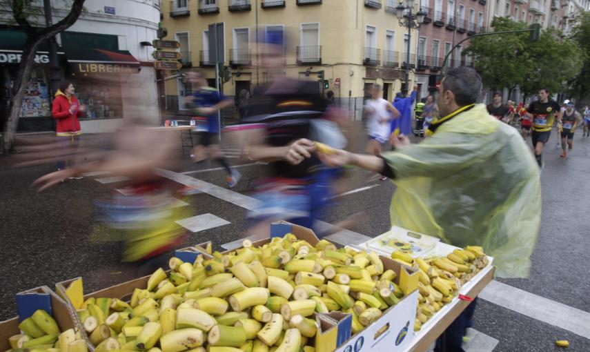 Corredores del maratón de Madrid reponen fuerzas a su paso por la calle Bailén. /Víctor Lerena (EFE)