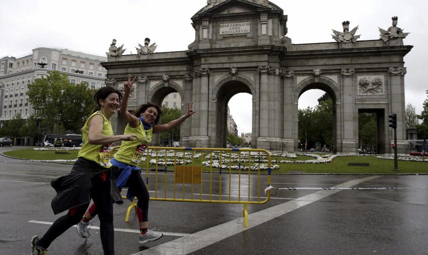 Dos participantes en el maratón de Madrid, a su paso por la Puerta de Alcalá. /Angel Díaz (EFE)