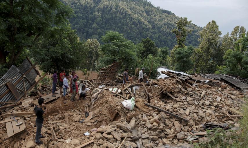 Habitantes de un pueblo junto a una casa derruida y totalmente dañada, donde tres personas han muerto por el terremoto, en el pueblo de Jharibar, en Gorkha, Nepal./ REUTERS-Athit Perawongmetha