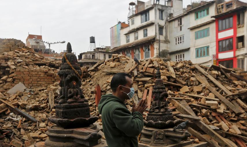 Un hombre reza al lado de los escombros de un templo, destruido el sábado a causa del terremoto, en Katmandú, Nepal./ REUTERS/Adnan Abidi