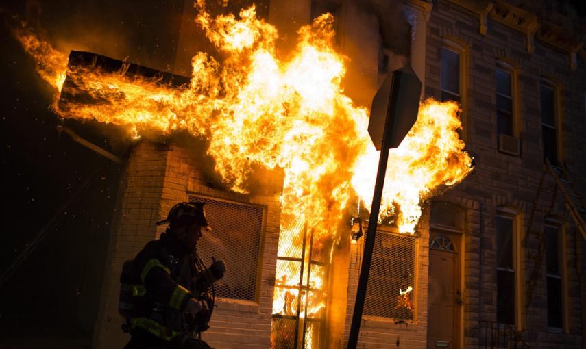 Los bomberos acuden a extinguir las llamas en un edificio durante los disturbios provocados en una protesta contra la muerte de Freddie Gray en Baltimore. EFE