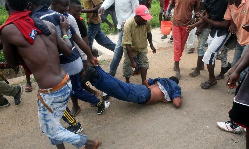 Una mujer policía es arrastrada por una multitud en Bujumbura. Los manifestantes la acusaron de haber disparado a los manifestantes  y a punto estuvieron de lincharla. Finalmente la agente pudo ser rescatada por sus compañeros- GORAN TOMASEVIC (REUTERS)