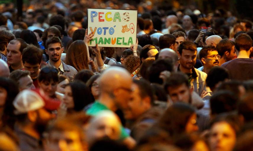 Un partidario de Ahora Madrid levanta un cartel, en el lugar de celebración de la coalición madrileña, tras las elecciones del 24-M, en Madrid.- PAUL HANNA (REUTERS)