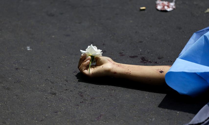 Una flor, depositada por un familiar en la mano de una víctima de un intento de robo en Ciudad de Guatemala.- JORGE DAN LOPEZ (REUTERS)