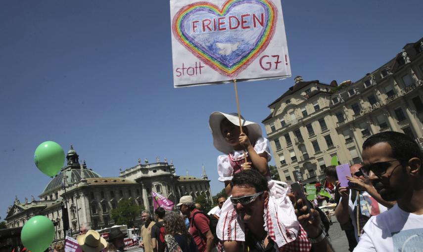 Una niña lleva una pancarta en la que se lee "Paz, no G-7" en la manifestación contra el TTIP y la cumbre del G-7 en Múnich, ante la cumbre de los siete países más ricos del mundo que se celebrará el 7 y 8 de junio en Baviera. EFE/Michael Kappeler