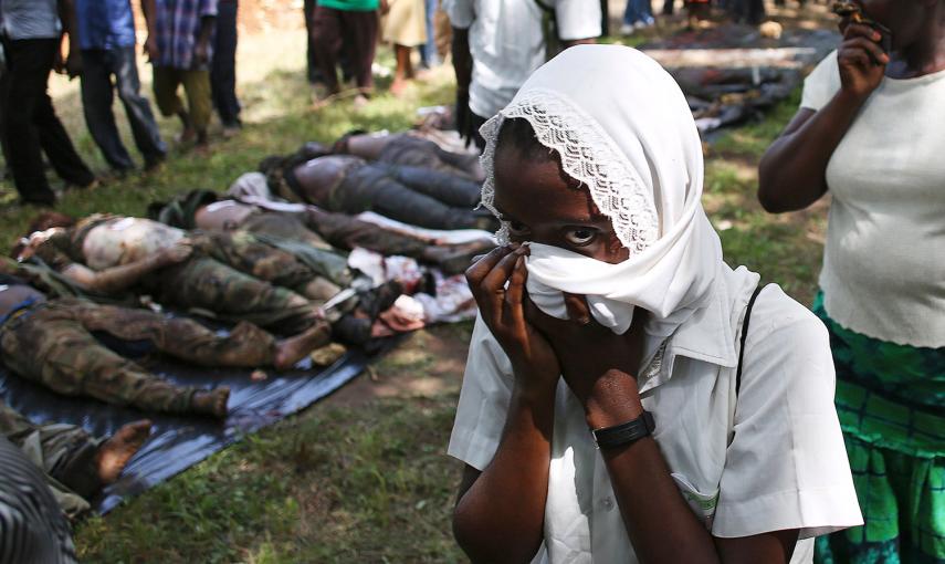 Una mujer pasa junto a los cadáveres de varios combatientes de Al-Shabaab, en Kenia.- GORAN TOMASEVIC (REUTERS)