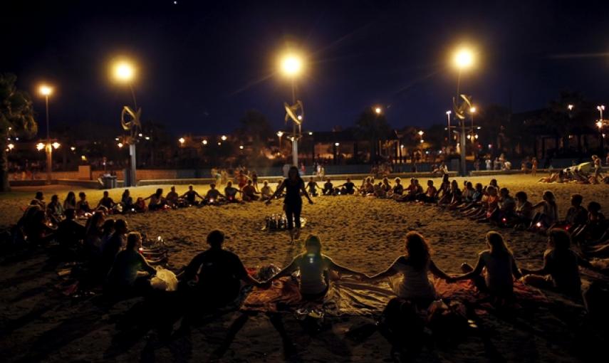La gente forma parte de un ritual para celebrar San Juan y llamar a la buena suerte en la Playa de la Misericordia de Málaga./ REUTERS/Jon Nazca