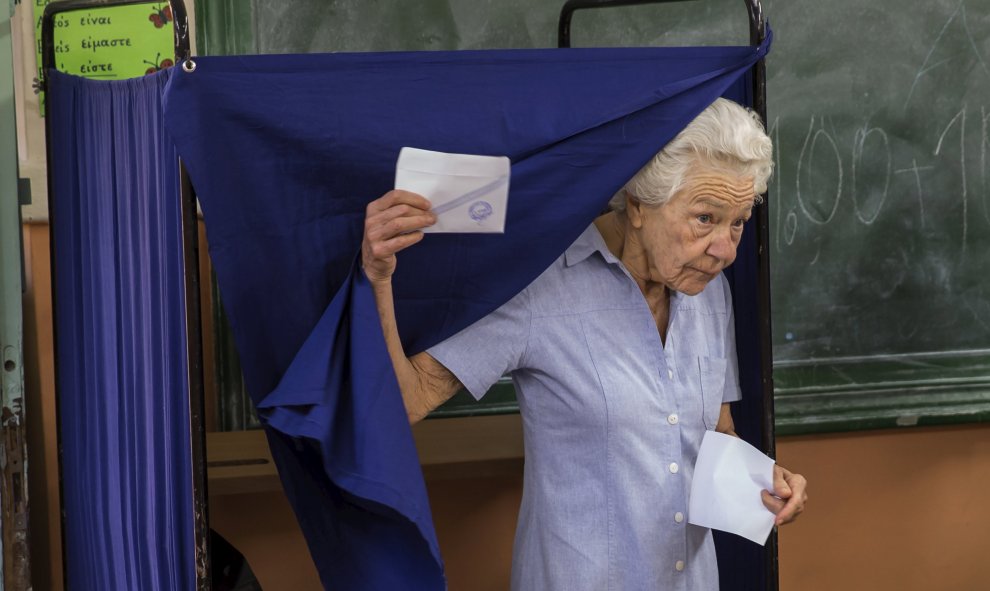 Una mujer sale de una cabina de votación para emitir su voto en un referéndum voto en Atenas. REUTERS/Marko Djurica