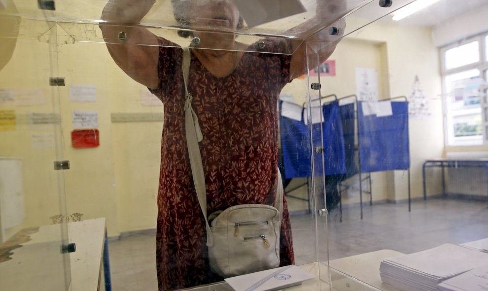 Una mujer deposita su voto en las primeras horas de votación en Grecia. REUTERS/Jean-Paul Pelissier