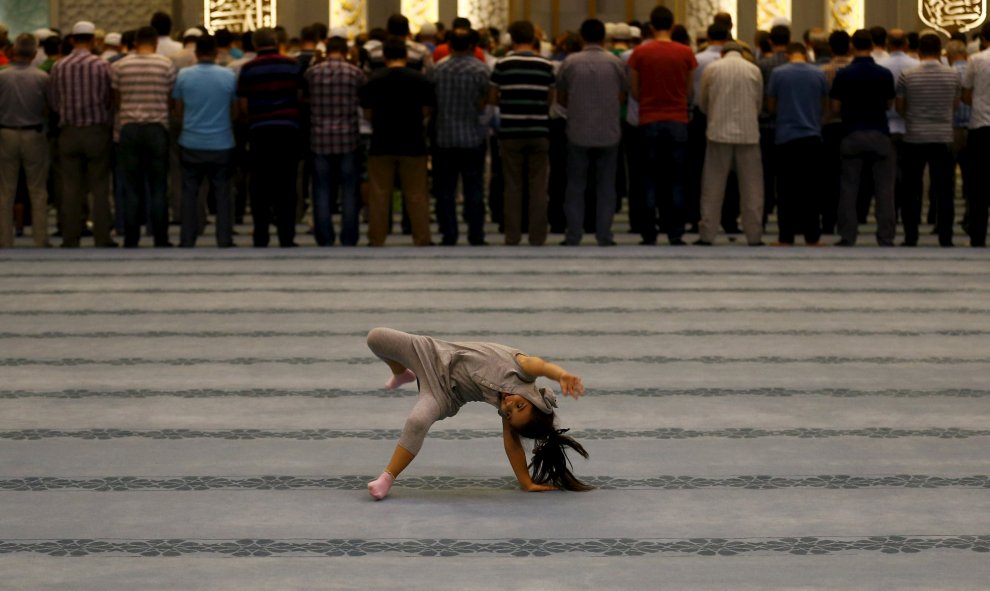 Una niña juega mientras un colectivo asiste a las oraciones de la noche en la mezquita de Ahmet Hamdi Akseki en Ankara, Turquía. REUTERS / Umit Bektas