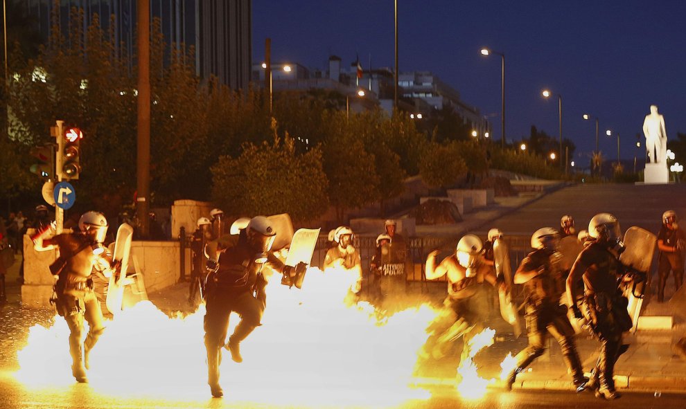 Una bomba incendiaria explota en medio de un grupo de antidiasturbios de la policía griega. EFE/ Yannis Kolesidis