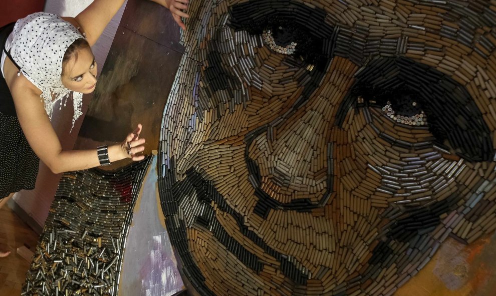 Artista ucraniana, Dariya Marchenko, trabaja en un retrato del presidente ruso, Vladimir Putin, llamado "La cara de la Guerra ", que está hecha de 5,000 cartuchos traídos de la línea del frente en el este de Ucrania, en Kiev. REUTERS / Gleb Garanich