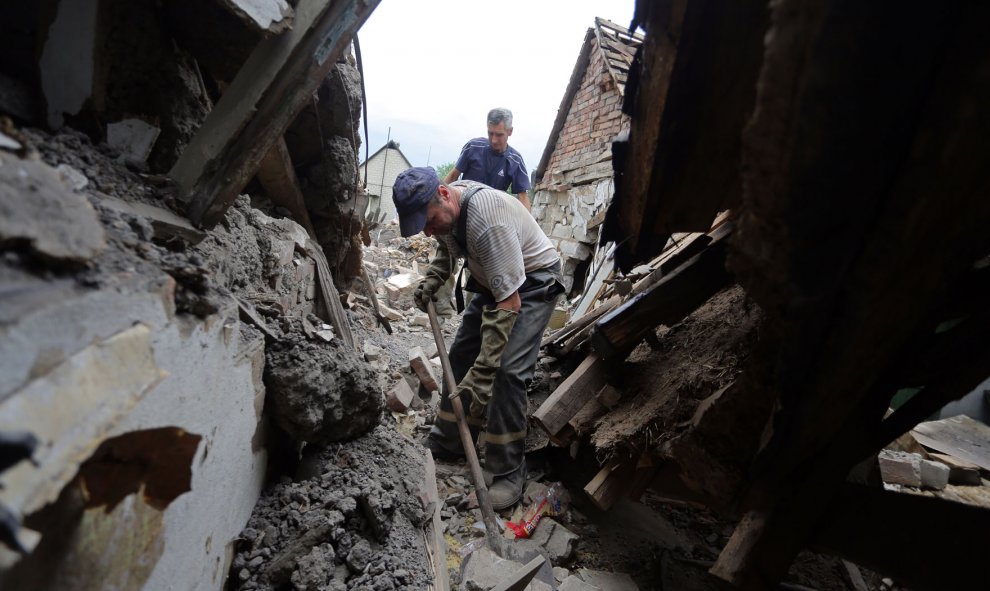 Los equipos de rescate tratan de localizar el cuerpo de una mujer atrapada bajo los escombros de su casa en el pueblo de Golmovsky cerca Gorlivka en la región de Donetsk después de los bombardeos entre las fuerzas ucranianas y los separatistas pro- rusos