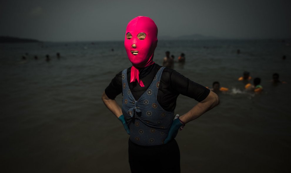 Una mujer posa con un facekini en la playa en Qingdao, provincia oriental china de Shandong. AFP PHOTO / FRED DUFOUR