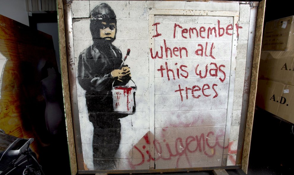 Nueva obra de Banksy: "Recuerdo que cuando todo esto era árboles" que se muestra dentro de una caja en un almacén en Beverly Hills, California. El enorme mural pintado en una fábrica de automóviles en Detroit sale a subasta en Beverly Hills y podría costa