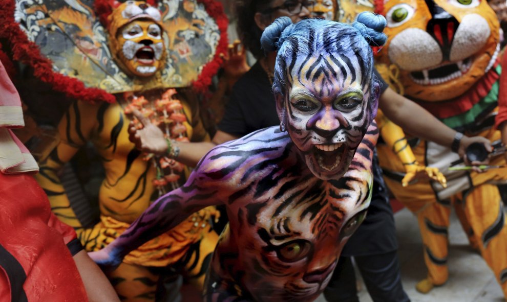 Bailarines indios, pintados y disfrazados de tigres, actúan durante el Día Internacional del Tigre en Calcuta, India, hoy 29 de julio de 2015. Varios estudiantes de Calcuta tratan de sensibilizar a la población sobre la difícil situación de los tigres en