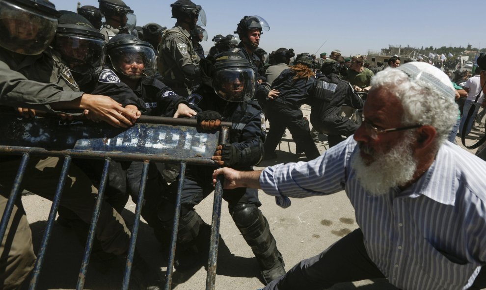 Un colono judío se enfrenta a miembros de las Fuerzas de seguridad israelíes, durante la demolición de un inmueble en el asentamiento judío de Bet El, cerca de la ciudad cisjordana de Ramala, hoy, 29 de julio de 2015. El movimiento colono judío convirtió