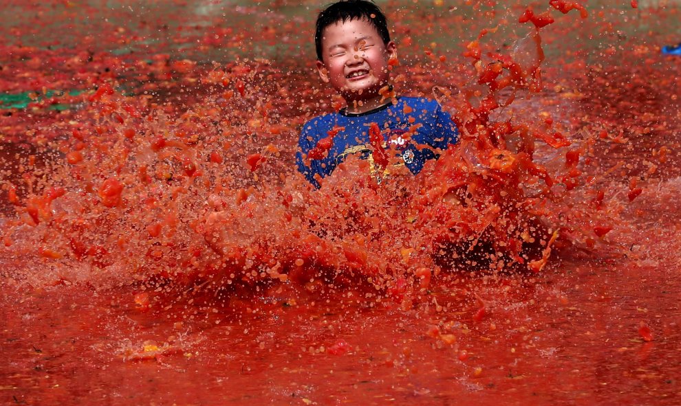 Un niño surcoreano se divierte en una piscina de tomate durante el 13 Festival del Tomate de Hwacheon, en la provincia de Gangwondo (Corea del Sur), hoy, 31 de julio de 2015. La Tomatina surcoreana se celebra del 30 de julio al 2 de agosto. EFE/Jeon Heon-