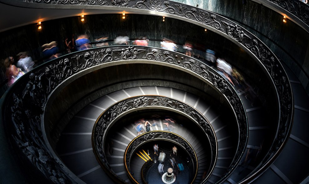 Visitantes recorren las escaleras de los Museos Vaticanos diseñadas por Giusepe Momo en 1932.- GABRIEL BOUYS (AFP)