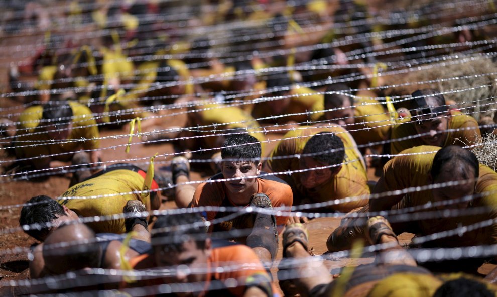 Competidores se arrastran debajo del alambre en la Carrera Bravus en Brasilia. La carrera desafía a los competidores con varios obstáculos en un trayecto de hasta 15 km. REUTERS / Ueslei Marcelino