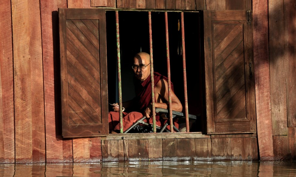 Un monje budista birmano permanece sentado en el interior de un monasterio inundado en Nyaung Don, birmania, hoy, 5 de agosto de 2015. El Gobierno de Birmania solicitó ayer ayuda internacional para asistir a los más de 210.000 damnificados por las inundac