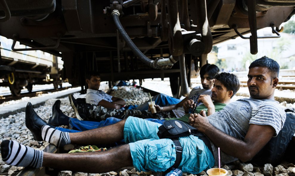 Inmigrantes paquistaníes descansan bajo un vagón en las vías del ferrocarril en la estación de tren en Gevgelija, el 5 de agosto de 2015. Muchos inmigrantes tratan de cruzar Macedonia y Serbia para entrar en la Unión Europea a través de Hungría, un país q
