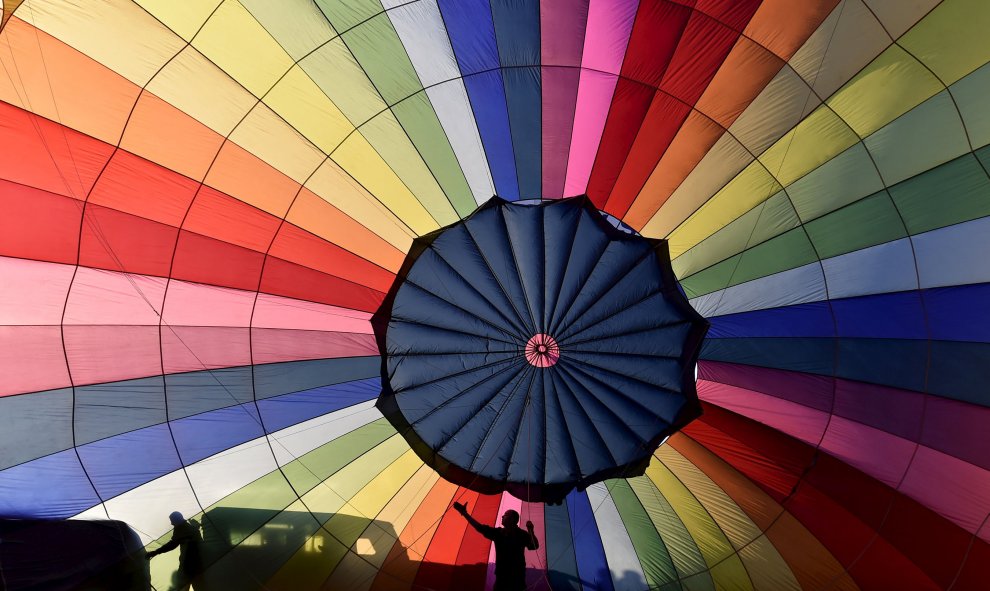 Miembros de la tripulación inflan un globo durante un lanzamiento masivo en la fiesta Internacional de Globos en Bristol, en el suroeste de Inglaterra, 7 de agosto de 2015. El festival de globos de aire caliente más grande de Europa cumple 37 años y tiene