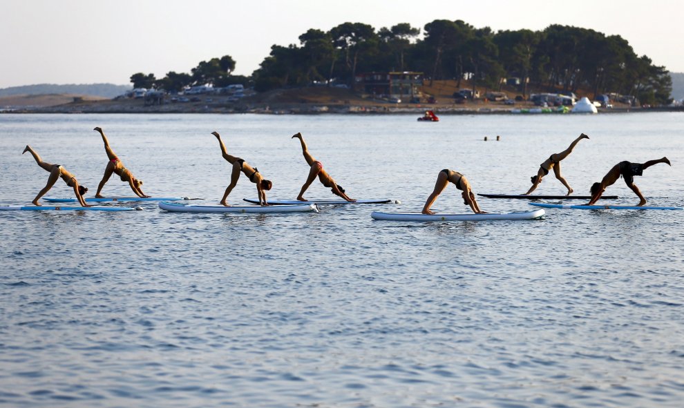 Varias personas practican una modalidad de Yoga en la costa adriática en Medulin, Croacia. REUTERS / Pawel Kopczynski