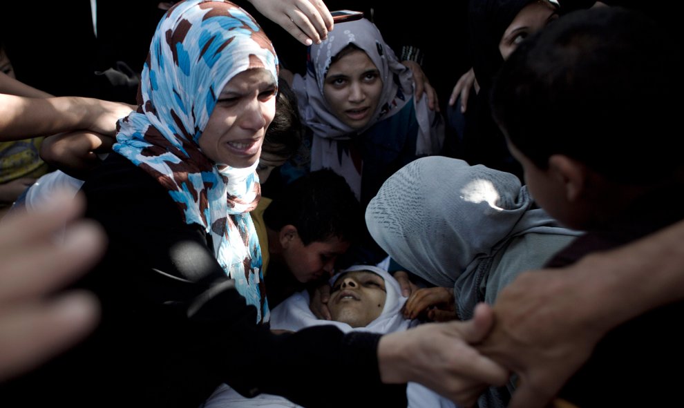 Familiares y amigos de Baker Abu Nuqeira, un palestino asesinado en una explosión que destrozó una casa en el campo de refugiados de Al-Shabura, cerca de la ciudad de Rafah, llora sobre su cadáver durante su ceremonia fúnebre .-AFP PHOTO / SAID KHATIB